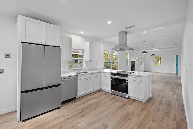 kitchen with white cabinetry, kitchen peninsula, island range hood, appliances with stainless steel finishes, and light wood-type flooring