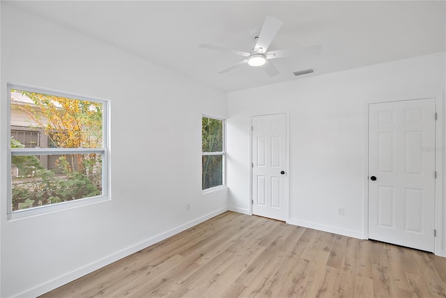 unfurnished bedroom featuring multiple windows, ceiling fan, and light hardwood / wood-style floors