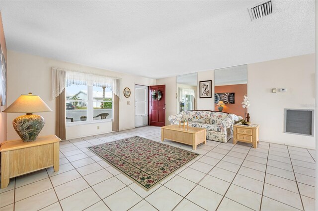 tiled living room featuring a textured ceiling