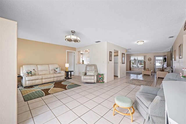 tiled living room featuring a textured ceiling