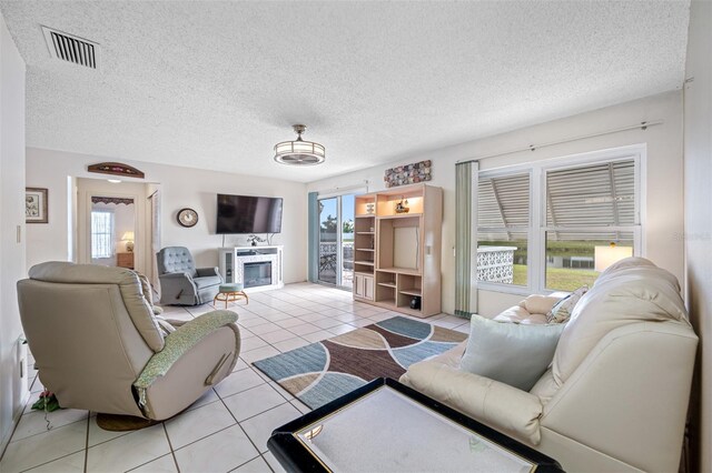 tiled living room with a textured ceiling and plenty of natural light