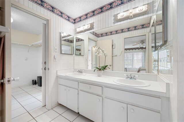 bathroom featuring vanity, a textured ceiling, ceiling fan, and tile patterned flooring