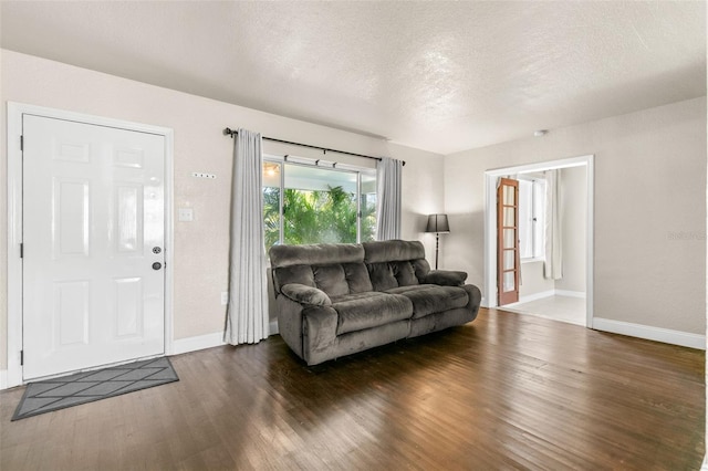 living room featuring a textured ceiling and dark hardwood / wood-style floors