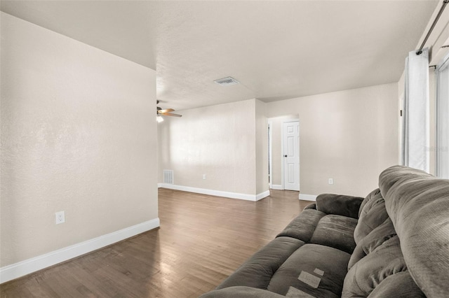 living room with ceiling fan and dark hardwood / wood-style flooring