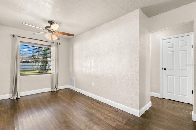 empty room with ceiling fan, dark hardwood / wood-style flooring, and a textured ceiling