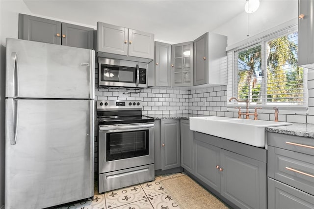 kitchen featuring gray cabinets, sink, appliances with stainless steel finishes, and tasteful backsplash