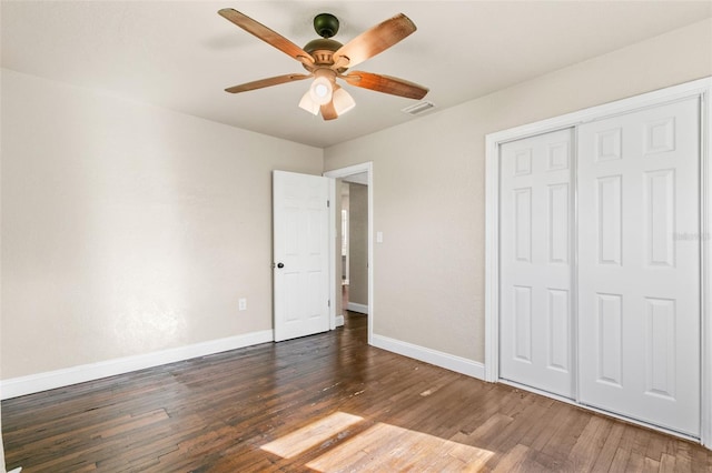 unfurnished bedroom with dark hardwood / wood-style flooring, a closet, and ceiling fan