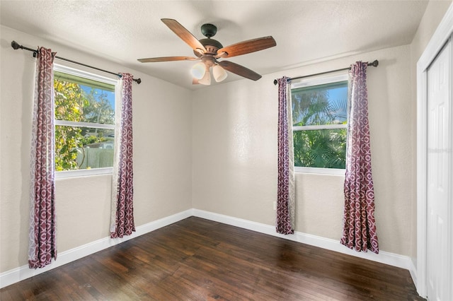 empty room featuring a textured ceiling, dark hardwood / wood-style flooring, and ceiling fan