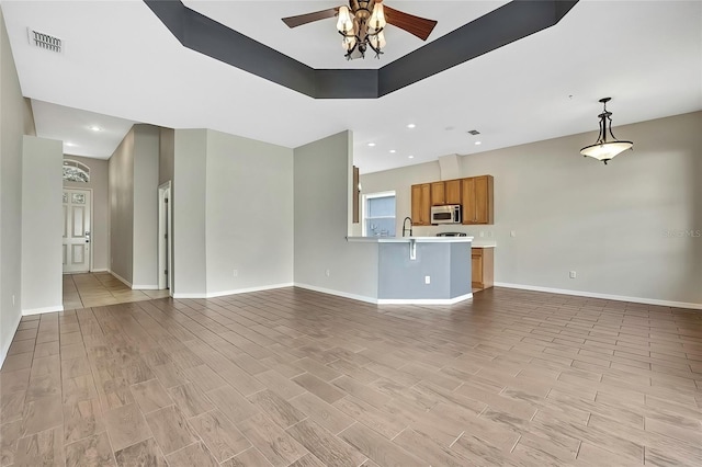 unfurnished living room with ceiling fan and sink