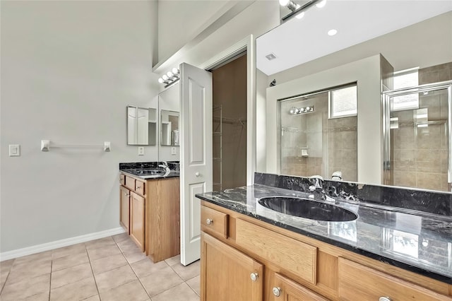 bathroom with tile patterned floors, vanity, and a shower with door