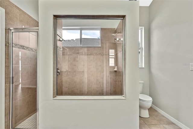 bathroom featuring tile patterned flooring, toilet, and a shower with door