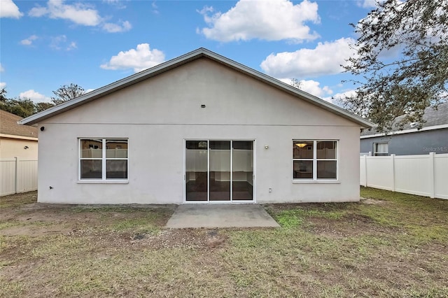 back of property featuring a patio area and a lawn