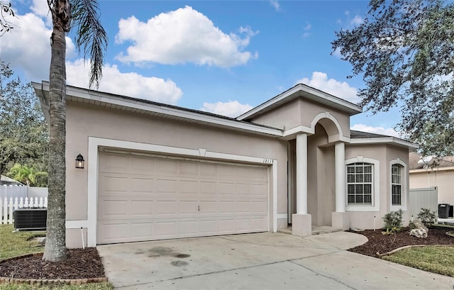 ranch-style home featuring cooling unit and a garage