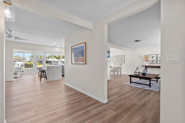 corridor featuring recessed lighting, visible vents, baseboards, and wood finished floors
