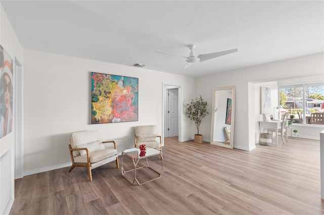 living area featuring light wood-style floors, baseboards, and visible vents