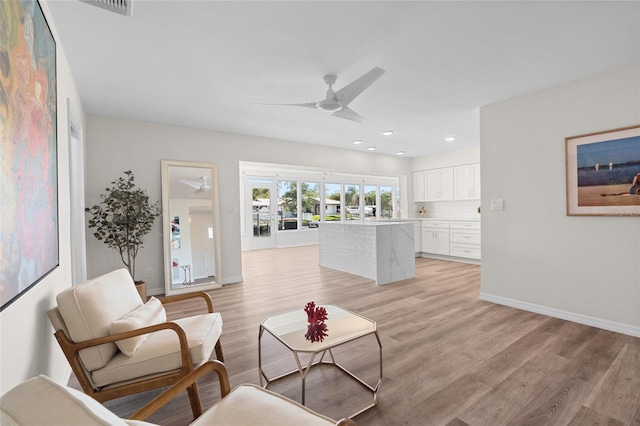 living area featuring light wood finished floors, ceiling fan, baseboards, and recessed lighting