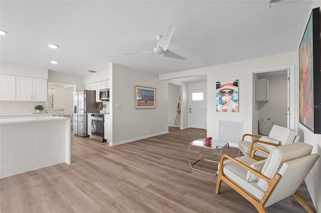 living area featuring baseboards, recessed lighting, a ceiling fan, light wood-style floors, and visible vents