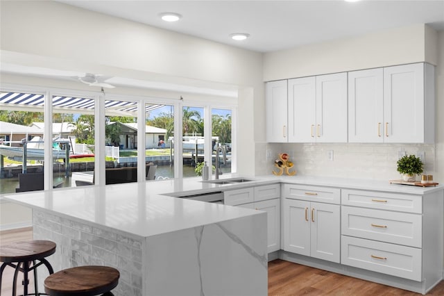 kitchen featuring a sink, white cabinetry, plenty of natural light, and a breakfast bar