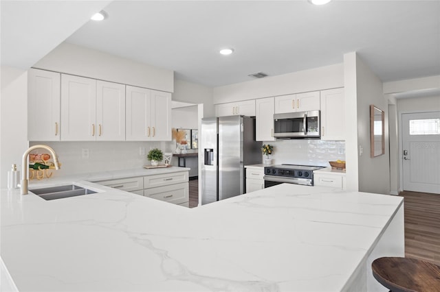 kitchen featuring a sink, visible vents, appliances with stainless steel finishes, and light stone countertops