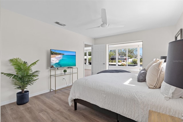 bedroom with wood finished floors, ceiling fan, baseboards, and visible vents