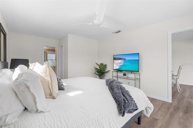 bedroom with wood finished floors, ceiling fan, baseboards, and visible vents