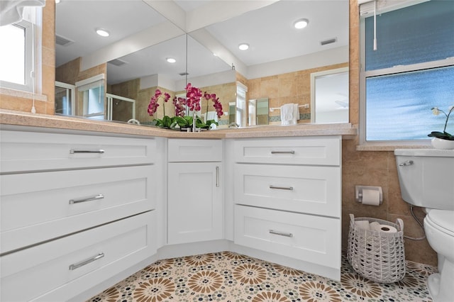 full bathroom with tile patterned flooring, toilet, a shower stall, visible vents, and tile walls