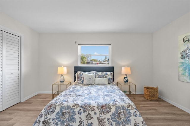 bedroom featuring a closet, baseboards, and wood finished floors