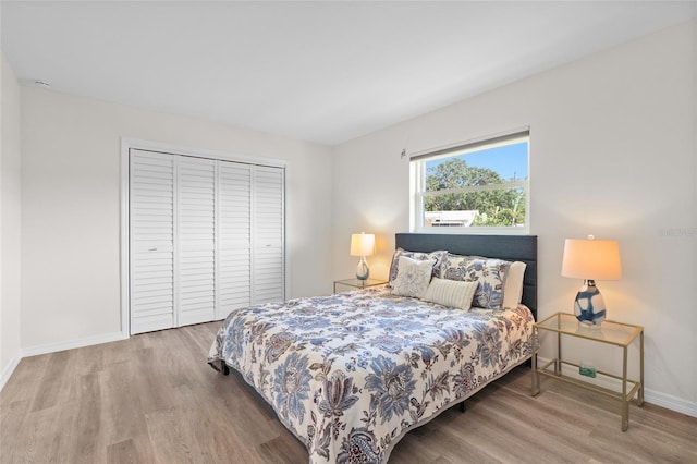 bedroom with a closet, baseboards, and wood finished floors