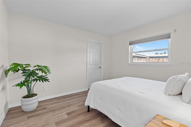 bedroom featuring baseboards and wood finished floors