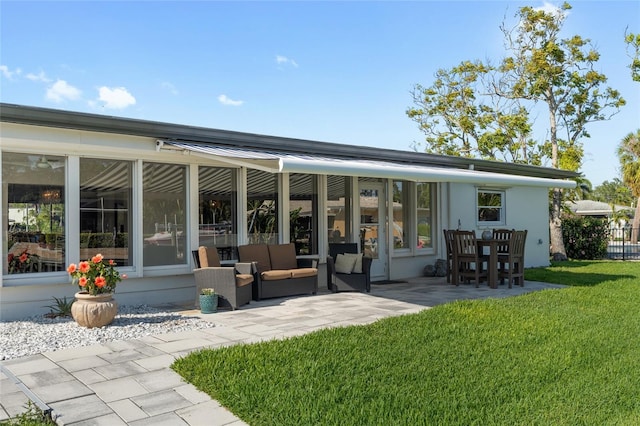 rear view of property featuring a patio and a lawn