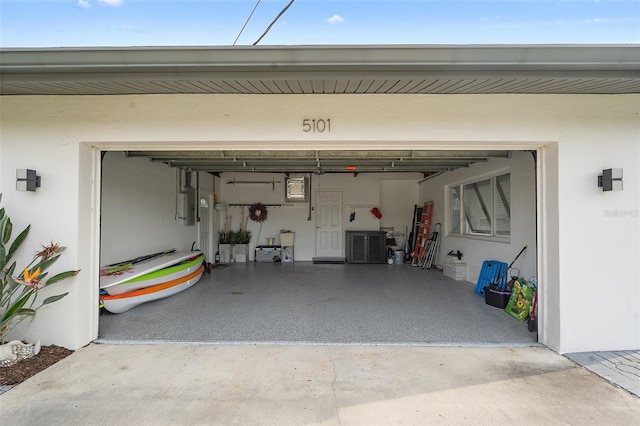 garage featuring concrete driveway and electric panel