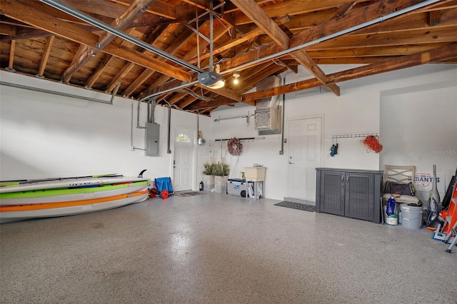 garage with a sink, a garage door opener, and electric panel