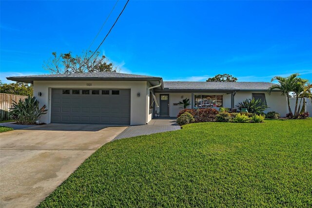 single story home with concrete driveway, stucco siding, a front yard, a garage, and fence