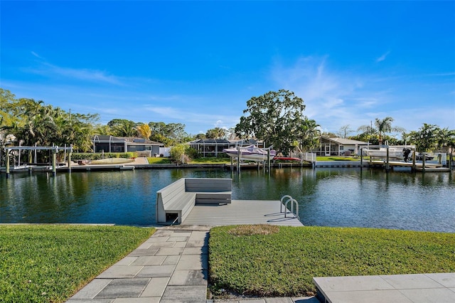 view of dock with a water view and a lawn