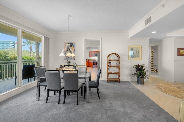 tiled dining space featuring crown molding and an inviting chandelier