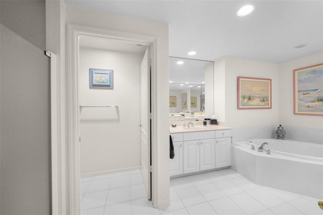 bathroom featuring tile patterned flooring, vanity, and tiled tub