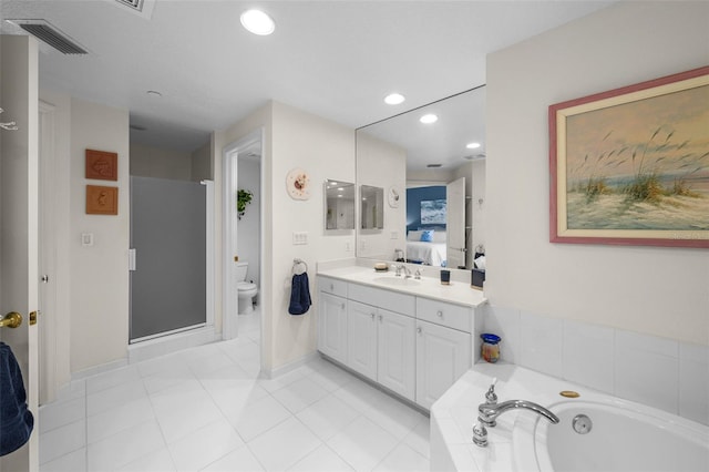 bathroom with tiled bath, tile patterned flooring, vanity, and toilet