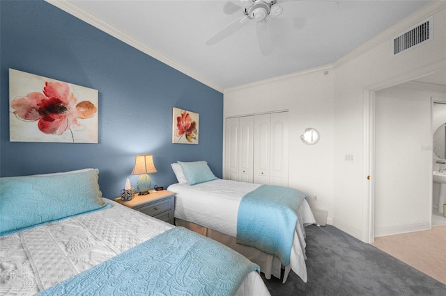 carpeted bedroom with a closet, ceiling fan, and crown molding