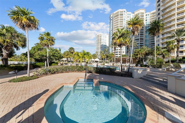 view of swimming pool with a patio area and a community hot tub