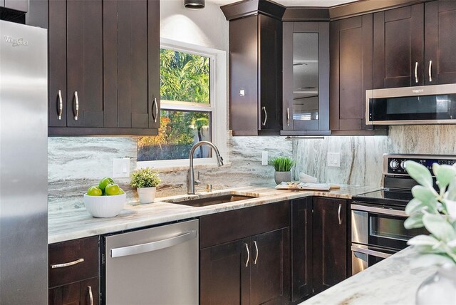 2461 61st Ln N, Saint Petersburg, FL 33710 - kitchen featuring appliances with stainless steel finishes, dark brown cabinetry, backsplash, and light stone counters