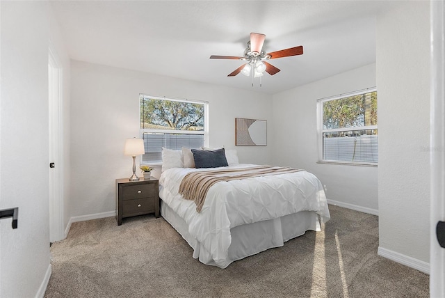 carpeted bedroom with multiple windows and ceiling fan