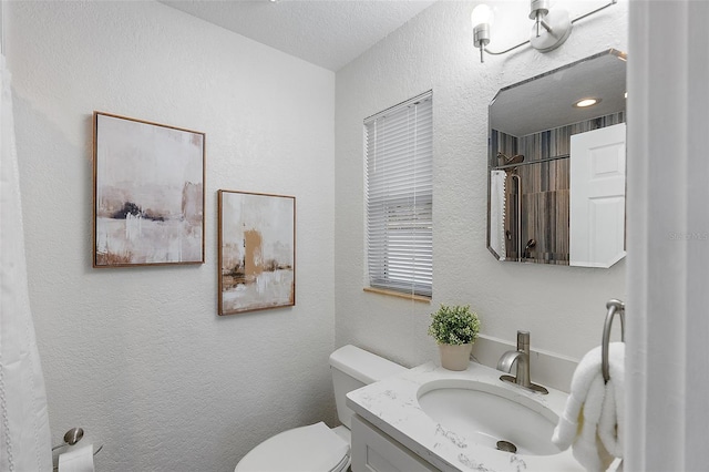 bathroom featuring curtained shower, vanity, a textured ceiling, and toilet