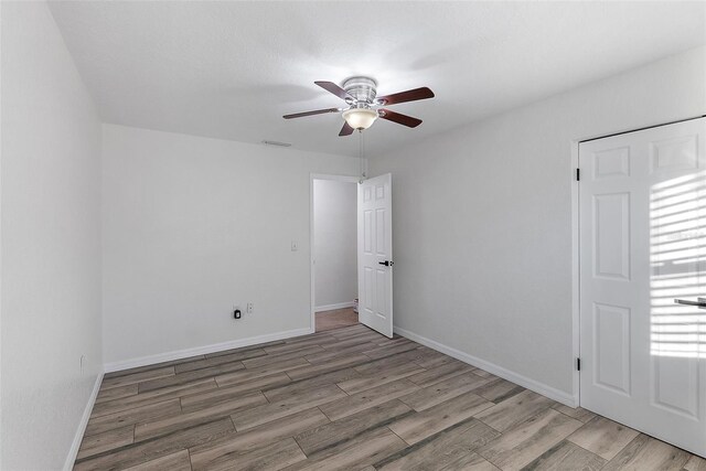 spare room with hardwood / wood-style flooring and ceiling fan