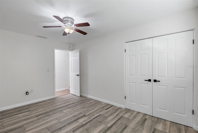 unfurnished bedroom with ceiling fan, a closet, and light hardwood / wood-style floors