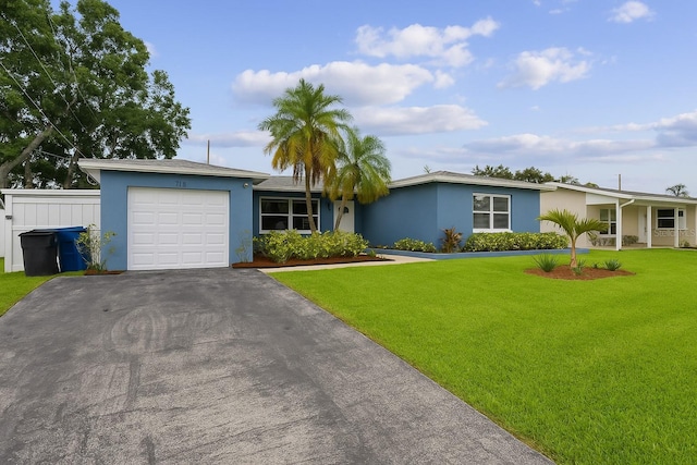 2461 61st Ln N, Saint Petersburg, FL 33710 - view of front of home with an attached garage, stucco siding, asphalt driveway, and a front yard