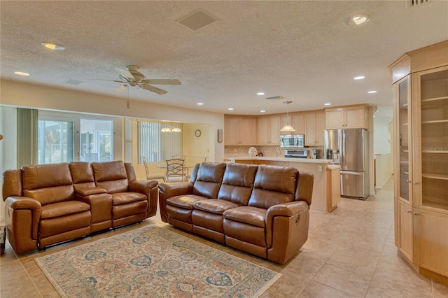 living room with ceiling fan and a textured ceiling