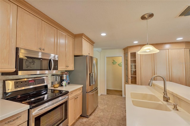 kitchen featuring sink, stainless steel appliances, decorative light fixtures, and light brown cabinets