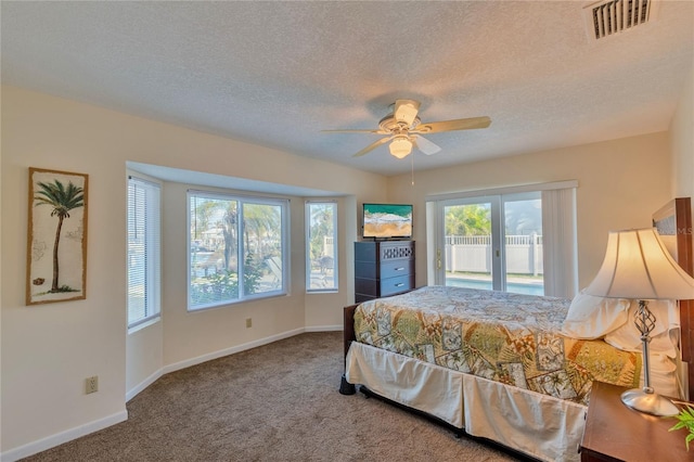 bedroom featuring ceiling fan, carpet floors, and a textured ceiling