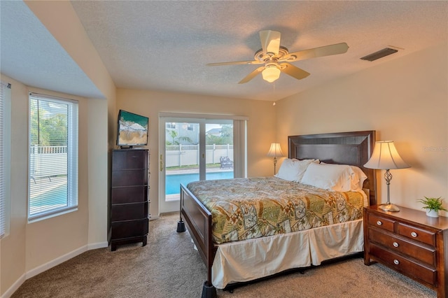 carpeted bedroom featuring multiple windows, a textured ceiling, access to outside, and ceiling fan