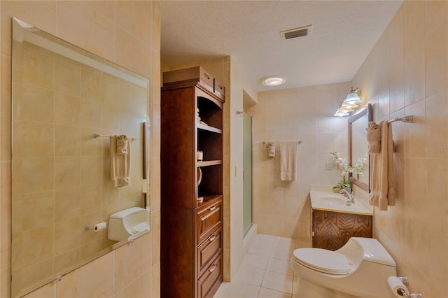 bathroom with an enclosed shower, a textured ceiling, and tile walls